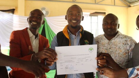 An image of Vincent Musyoka receiving his clearance certificate from IEBC.