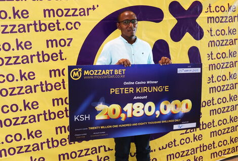 Image of Peter Kirunge receiving his cash prize from Mozzart Bet.