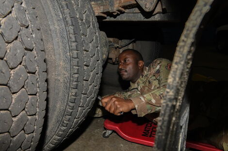 Senior Airman Patrick Ikua on duty repairing US military truck