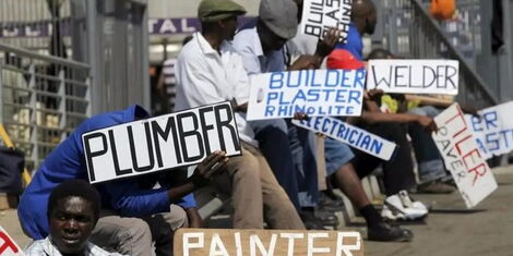 An image of jobseekers holding placards along a road. 