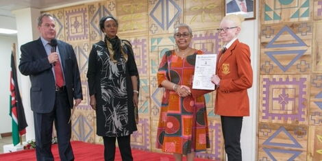 KCPE 2017 top candidate Goldalyn Kakuya (far right) receives her scholarship from First Lady Margaret Kenyatta