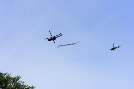 A military chopper with a banner written 'God bless medics' flies over Nairobi on Tuesday, April 21, 2020