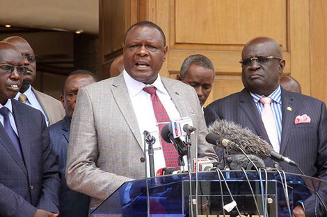 From left: Education PS Belio Kipsang, KESSHA Chairman Kahi Indimuli, and Education CS George Magoha address a press conference at Kenya Institute of Curriculum Development, on October 1, 2018
