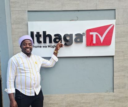 Kikuyu musician, Karangu Muraya points at the sign of Ithaga TV station on September 14, 2022.