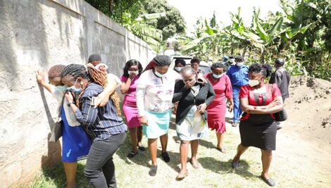 Relatives and residents of Karura village grief outside the home of a Kiambu family that was murdered