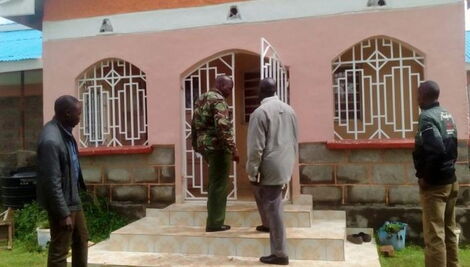 Kenya Police officers pictured outside a house designated as a crime scene.