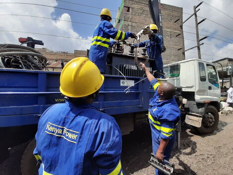 Kenya Power and Lighting Company engineers load a transformer onto a lorry.