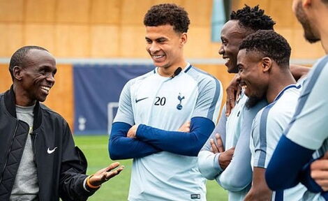 London Marathon champion Eluid Kipchoge (left) interacts with Tottenham Hotspur players during a visit to the football club.