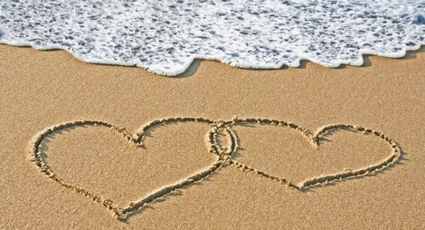 Love hearts drawn on a beach.