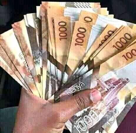 A Picture of a hand holding Kenyan notes.