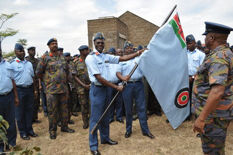 Major General Mohammed Badi Ali (2nd from left, in military fatigue) looks on as former KAF Commander Maj Gen Joff Otieno hands over the service flag to the incoming commander Maj Gen Samuel Thuita in July 2014