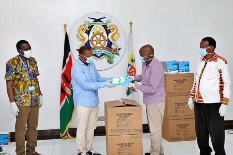 A Mombasa County Government official receives a donation of 10,000 surgical masks from the Kitui County Government on April 26, 2020
