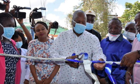 Health CS Mutahi Kagwe launches the Kenyatta National Hospital (KNH) Diagnostic and Reporting Centre, Nairobi in February 2020 as Health CAS Dr Mercy Mwangangi (behind) watches