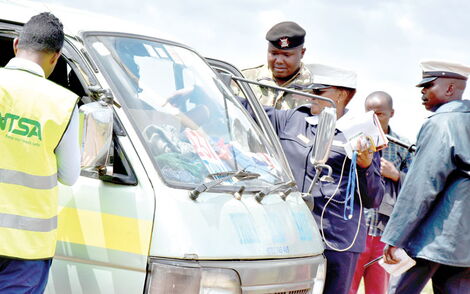 NTSA officials accompanied by police inspect a matatu in Nairobi in December 2019