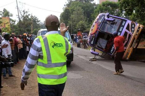 An NTSA official marshalls traffic at a past accident scene