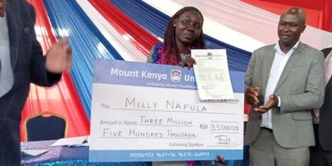 Image of Milly Nafula receiving scholarship from Mount Kenya University founder Prof Simon Gicharu.