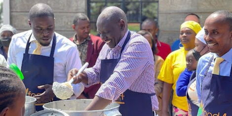 Nairobi Governor Johnson Sakaja watches as President William Ruto serves food to pupils at Mukarara Primary School in Nairobi. on May 11, 2022.