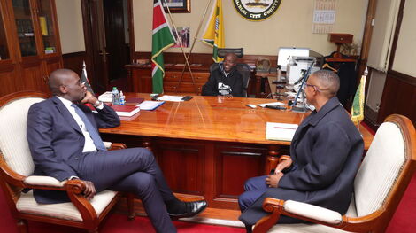 Nairobi Governor Johnson Sakaja at his office with a young boy he rescued and a county staff on Monday, November 14, 2022
