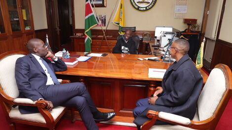 Nairobi governor Johnson Sakaja at his office with a young boy he rescued and a county staff on Monday November 14, 2022