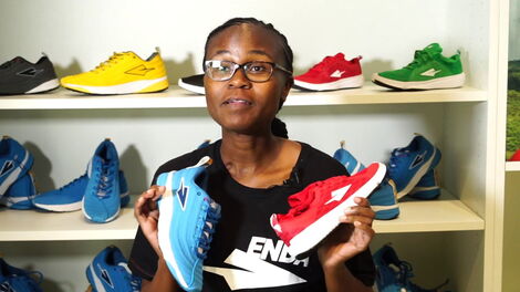 Osembo Navalayo, CEO of Enda Sportswear, holding some of his shoe brands