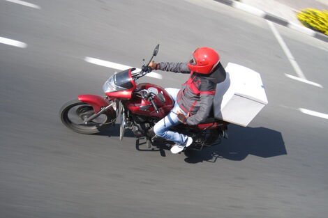 A delivery service provider using a motorcycle to ferry goods