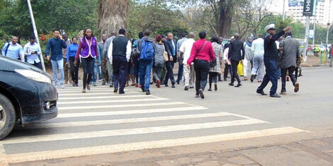 Pedestrians assisted by traffic police at a zebra crossing in Nairobi, on Monday, October 21, 2019
