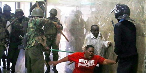 Police men assaulting a civilian.