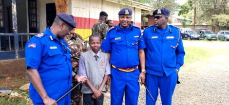 Police in Machakos pose for a photo with Simon Muthama