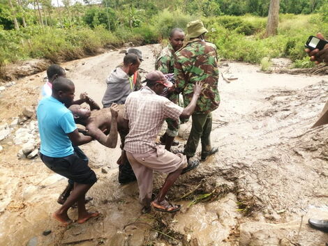 Police officer and local residents rescue a man who was trapped following the landslide that hit West Pokot County on April 18, 2020.