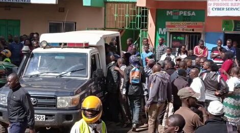 Police officers pictured at a scene of a crime as residents look on.