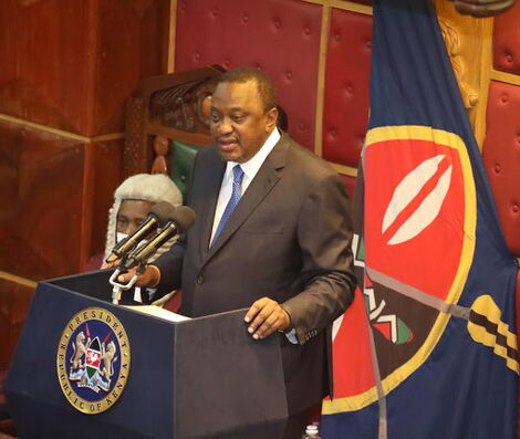 President Uhuru Kenyatta making an address in Parliameent, behind him is the Presidential Standard.