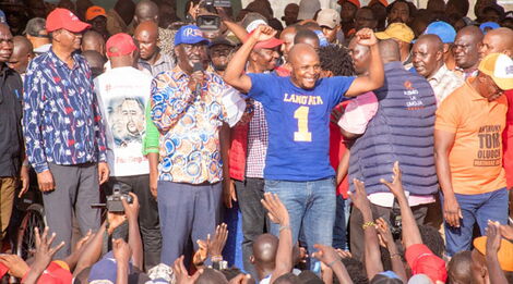 Azimio leader Raila Odinga (holding microphone) and Phelix Odiwuor ( raising hands) address a rally at Undugu Grounds in Lang'ata, Nairobi County in June 2022. 