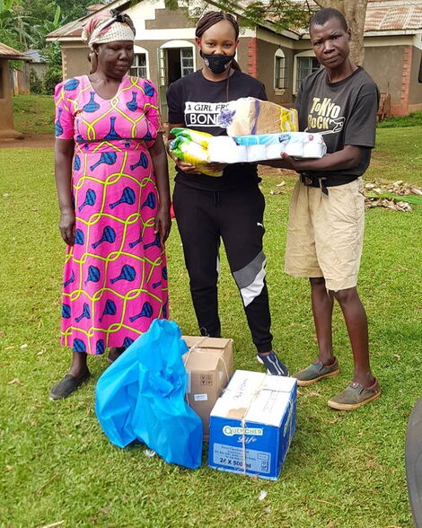 Carol Radull (centre) poses with boxer Conjestina Achieng' and her mother after donating various supplies