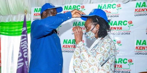 Raila Odinga (left) crowns Martha Karua with an Azimio la Umoja -branded cap at Serena Hotel, Nairobi on Wednesday, March 23, 2022..jpg