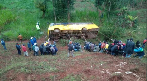 Local residents try to rescue an overturned school bus on the Meru-Nairobi Highway in Tharaka Nithi.