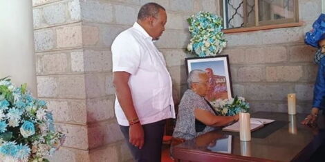 Retired President Uhuru Kenyatta (left) watches his wife Margaret Kenyatta sign the late George Magoha's condolence book on Tuesday, January 31, 2023.
