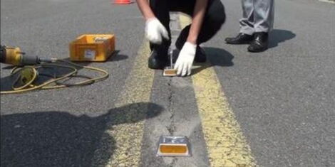 An engineer installing road studs along a highway.
