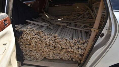 Several rolls of bhang packed behind a car.