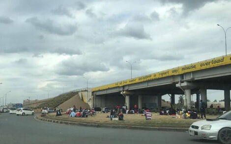 Nairobi Residents relaxing along a roundabout along a major highway.