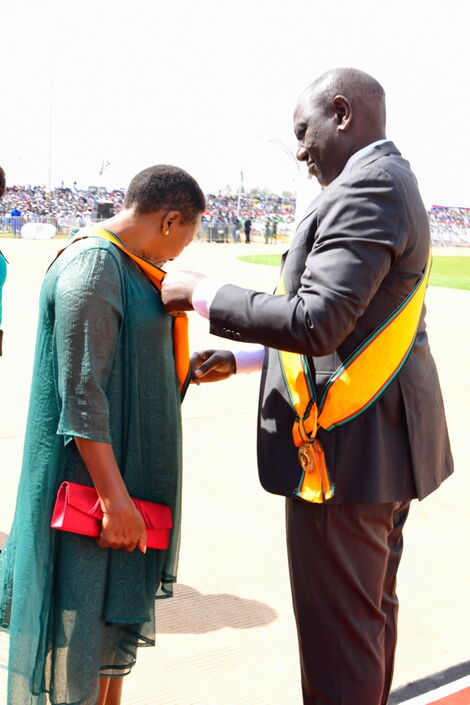 Vice President William Ruto helping Mama Racheal Ruto put on her ribbon during Madaraka Day celebrations on June 1, 2022.
