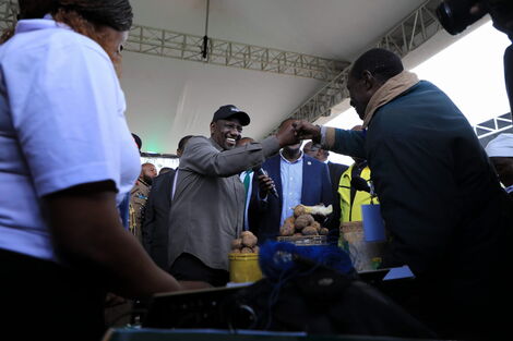 President William Ruto (in black cap) interacts with traders at the Green Park Terminus during the launch of the Hustlers Fund on November 30, 2022. 