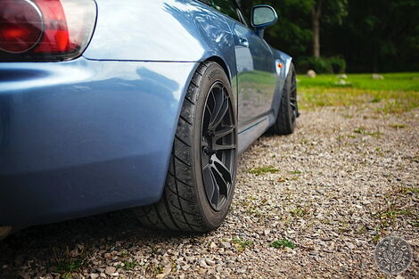 A photo of a parked vehicle with offset tyres.