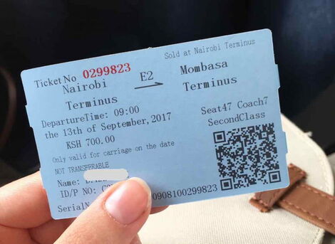 Hand holding a Madaraka Express ticket from Nairobi to Mombasa.