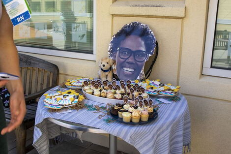 Several cupcakes with Gatimu's face together with her photo set on a table on her final day at work