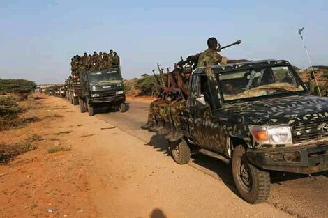 Trucks carrying Somalia troops with guns.