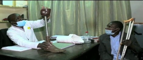  Name Stephen Chege Paying Attention to a Doctor Explaining To Him How His Prothetic Leg Would look Like