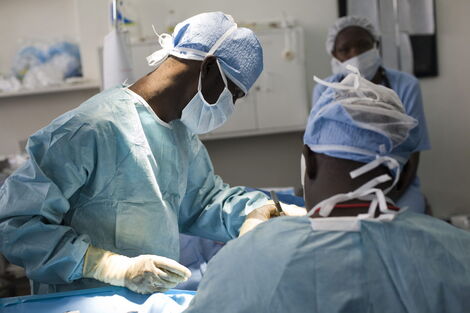 Surgeons performing surgery on a patient.