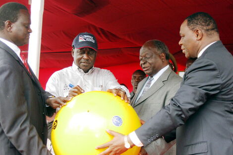 Former Minister for Information Samuel Poghisio (left) and former Permanent Secretary Dr. Bitange Ndemo (right) hold a huge buoy as President Kibaki (second right) looks on, and Prime Minister Raila Odinga (second left) at the Fort Jesus sea front on June, 12 2009. 