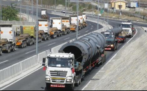 Trucks by Seven Stars Company on a road in Kenya