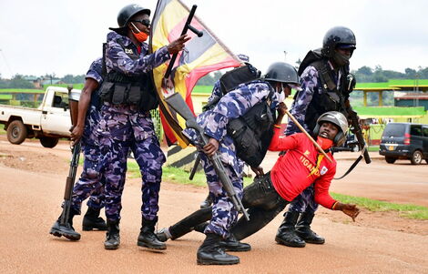 Ugandan riot police officers detain a supporter of presidential candidate Robert Kyagulanyi, also known as Bobi Wine